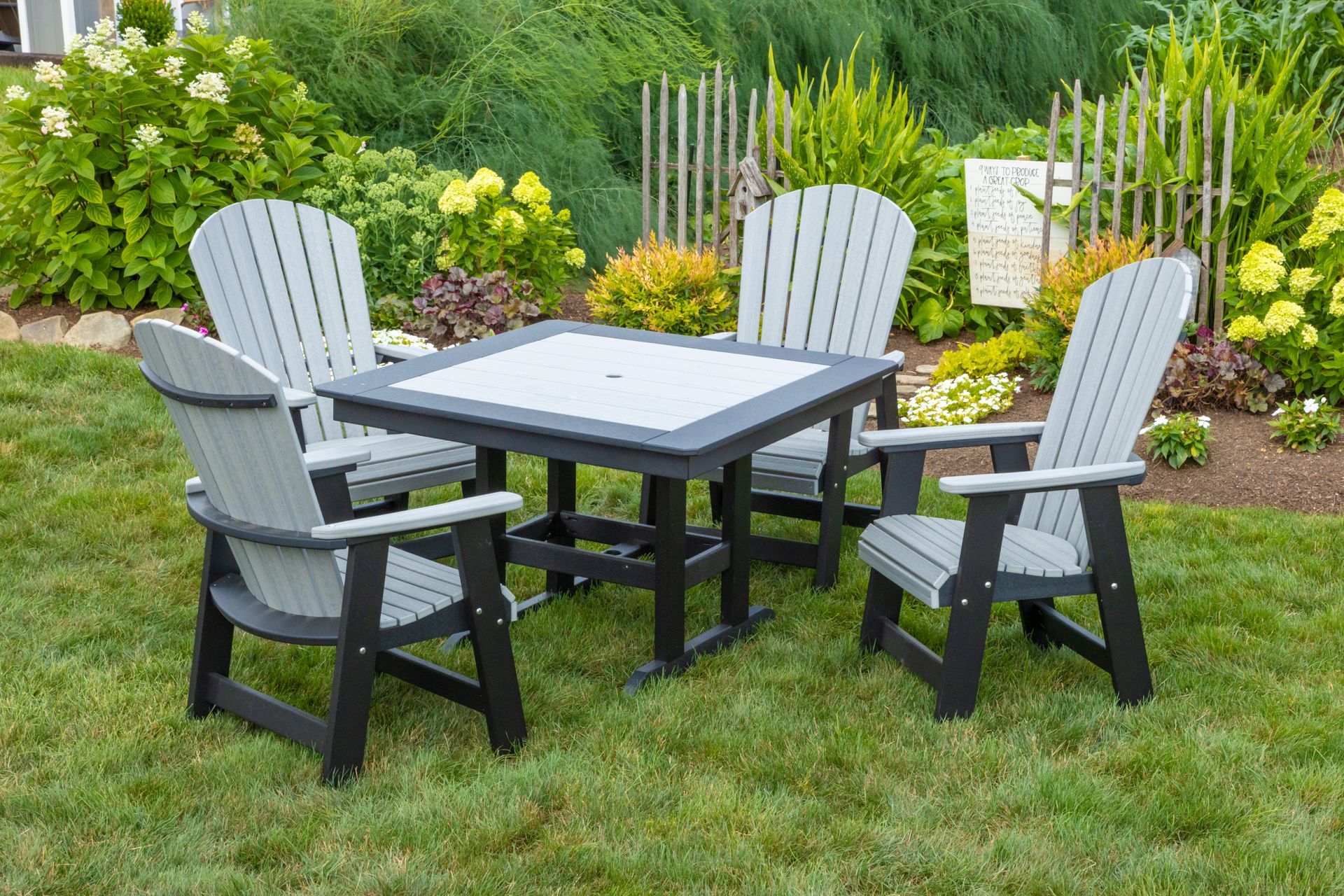 A table and chairs are sitting on top of a lush green lawn.