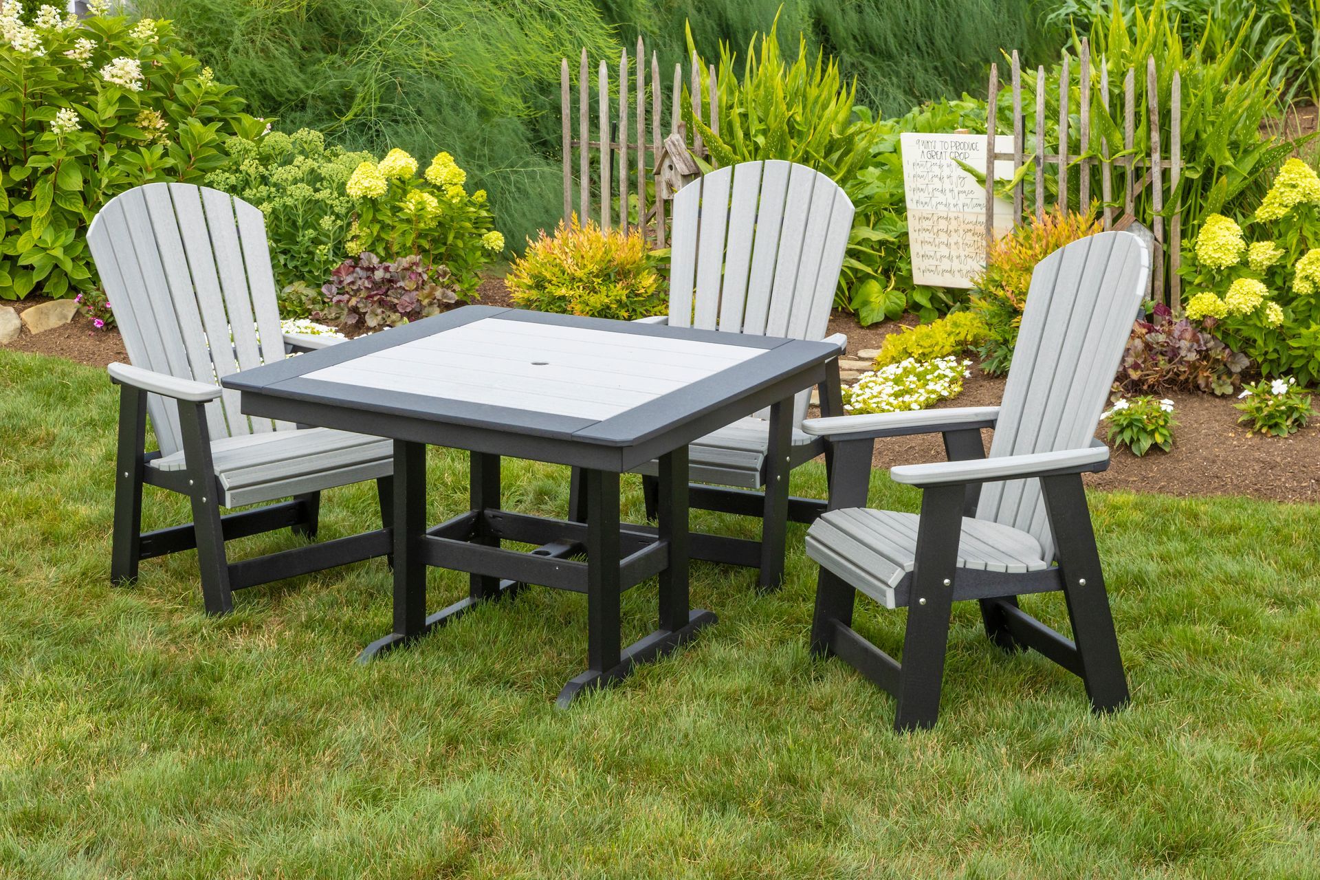 A table and chairs are sitting on top of a lush green lawn.