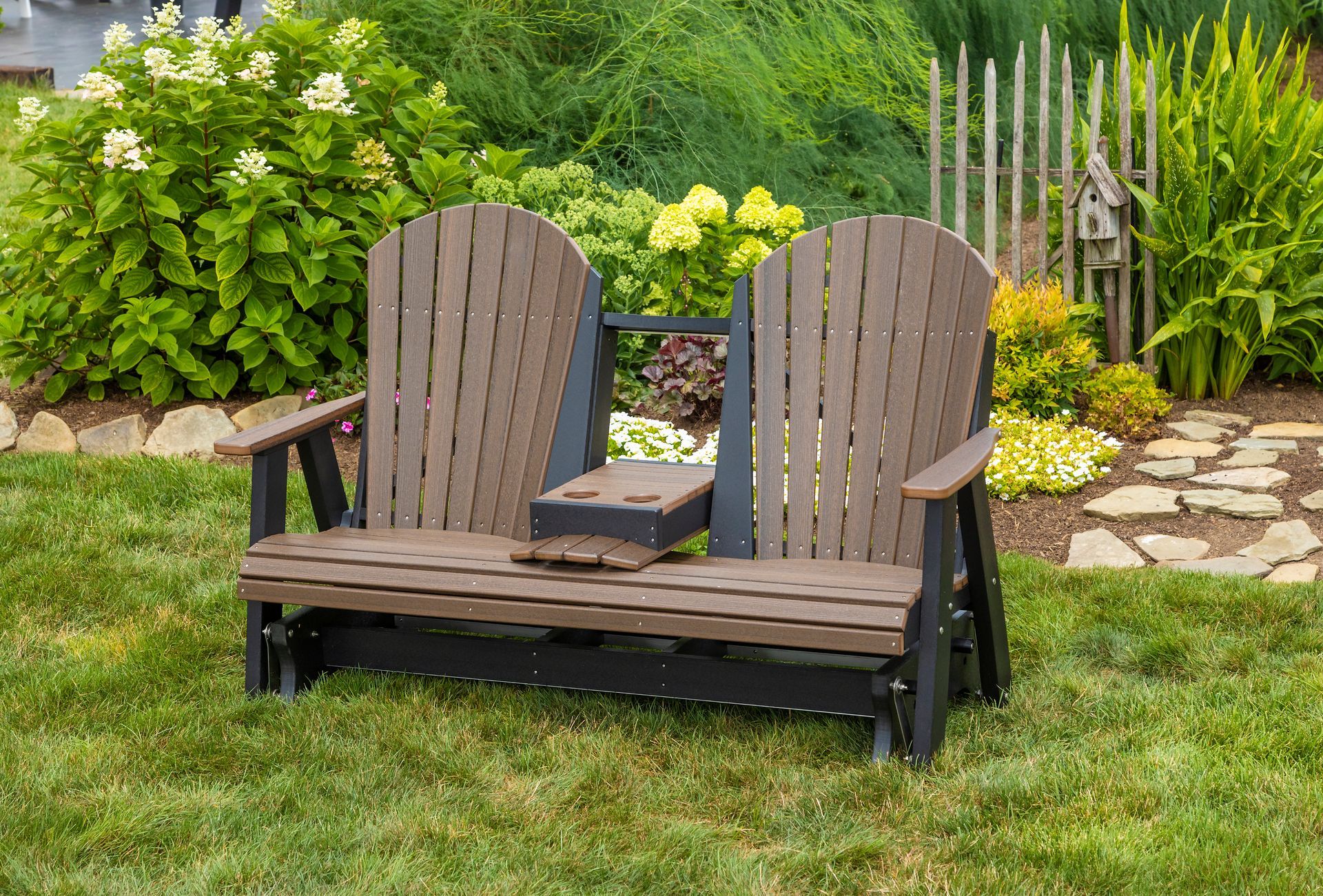 A wooden bench is sitting in the grass in a garden.