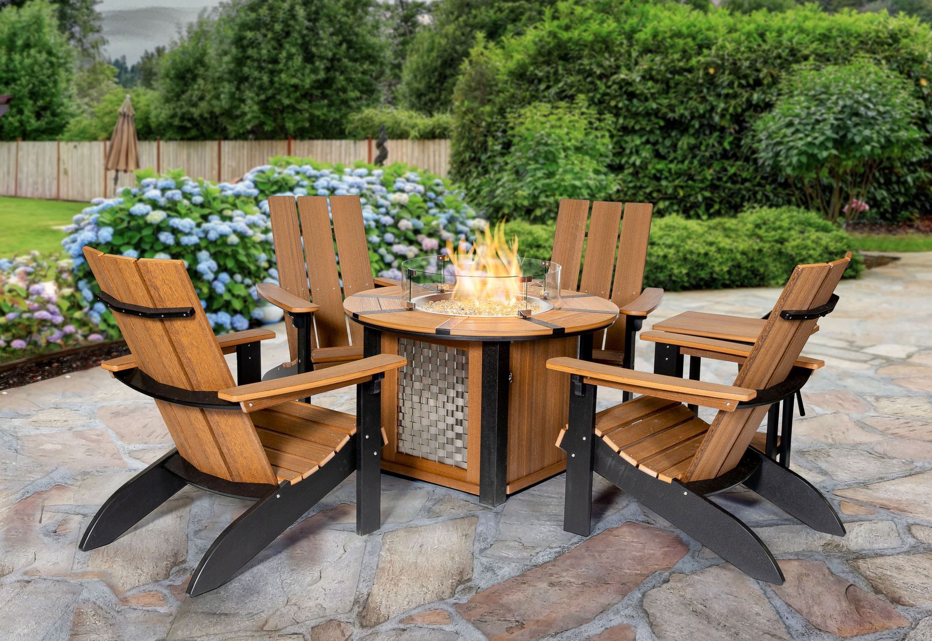 A fire pit is surrounded by wooden chairs on a patio.