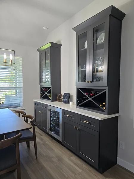 Dark gray built-in cabinets with a wine rack, glass-front upper cabinets, and a wine cooler.