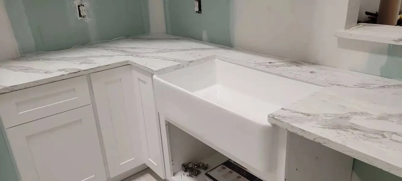 White kitchen sink installed with countertop and cabinetry.