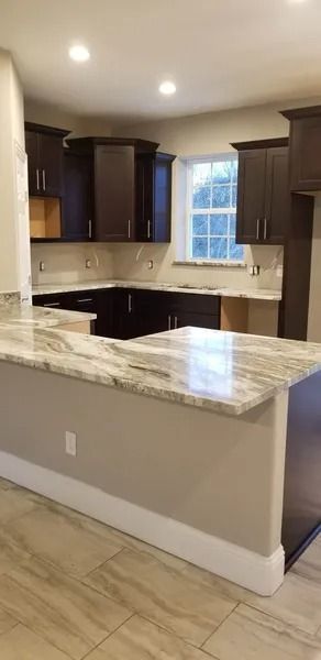 Kitchen with dark brown cabinets, light-colored countertops, and beige walls.