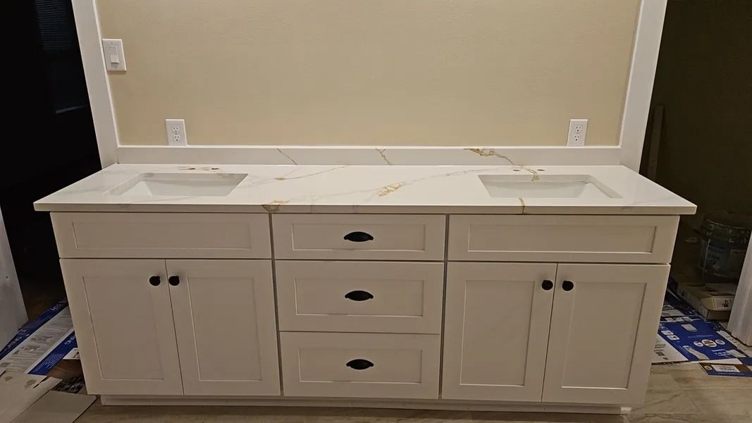 White double sink bathroom vanity with marble countertop and mirror.