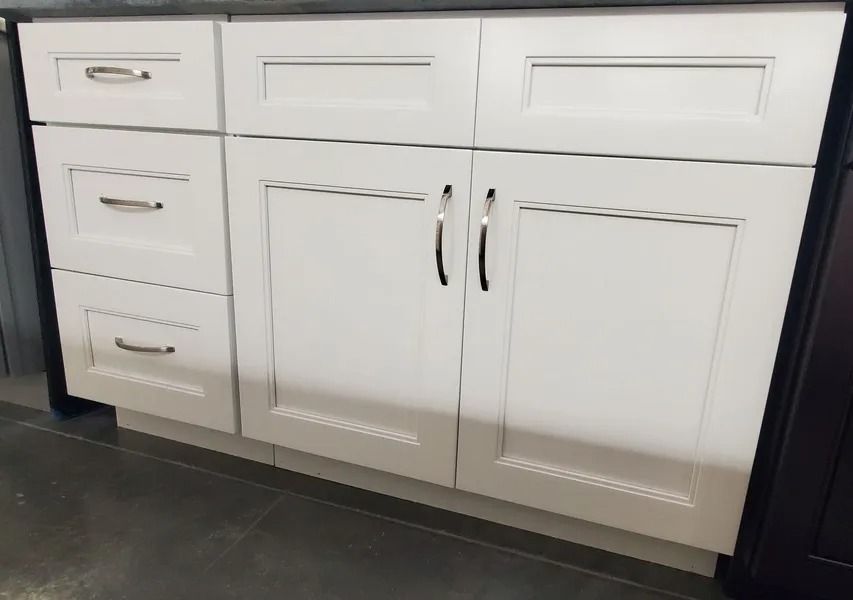 White bathroom cabinet with drawers and doors, silver handles.