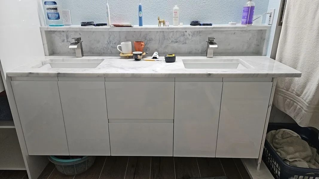 White double sink vanity with marble top in a bathroom.