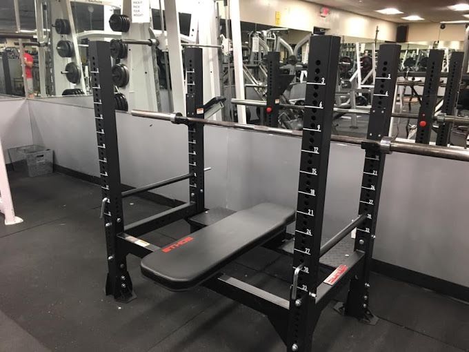 A squat rack with a bench in a gym.
