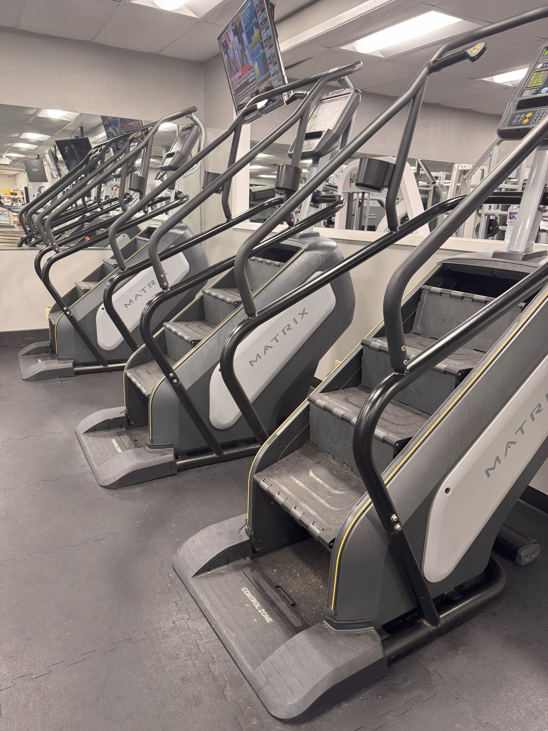 A row of stair climbing machines in a gym
