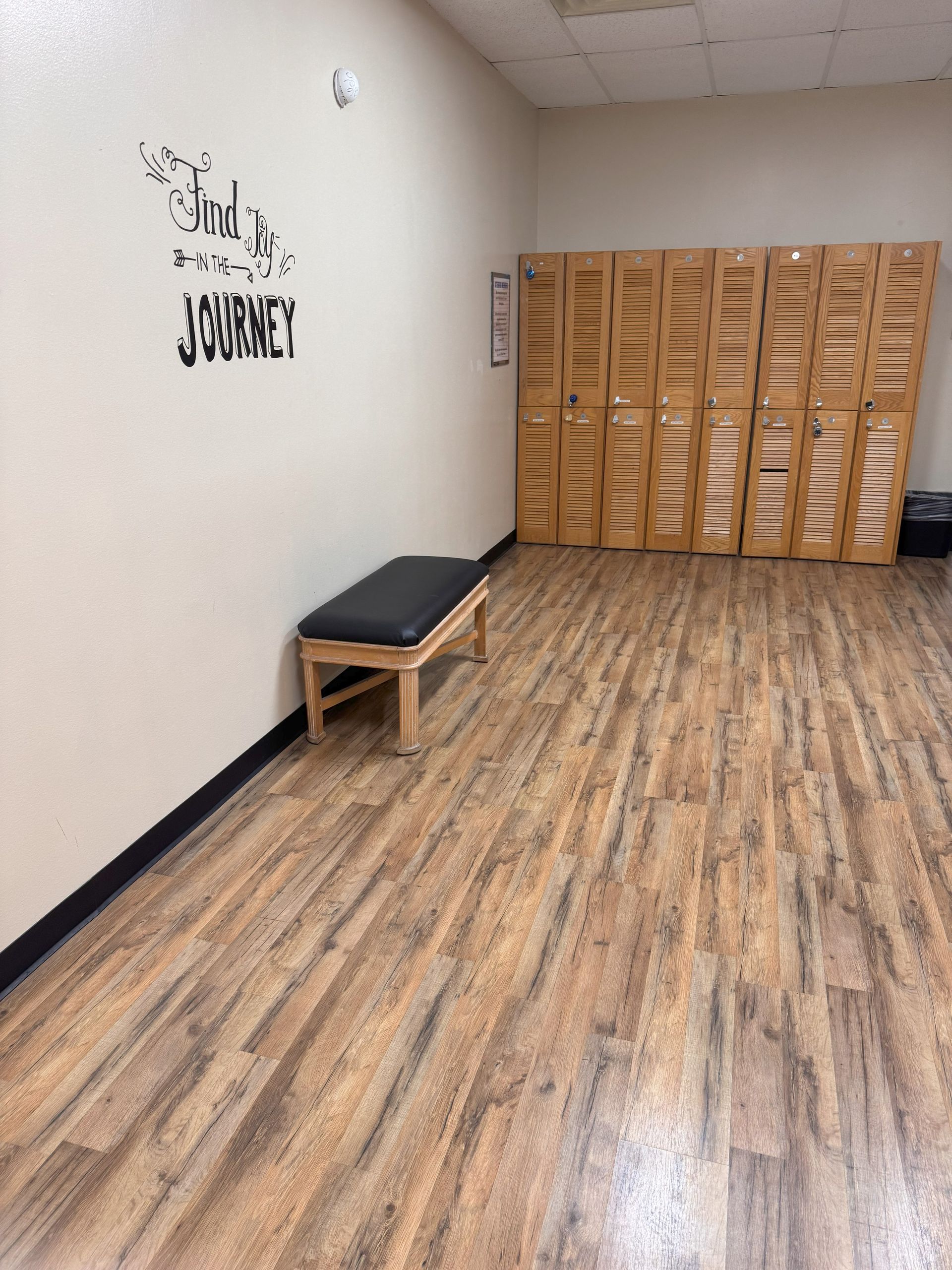 A locker room with wooden floors and a bench