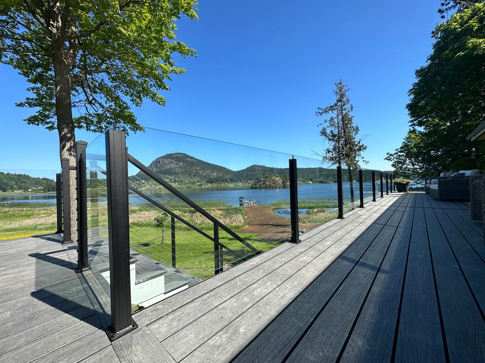 Newly installed deck floor, glass railings, and stair