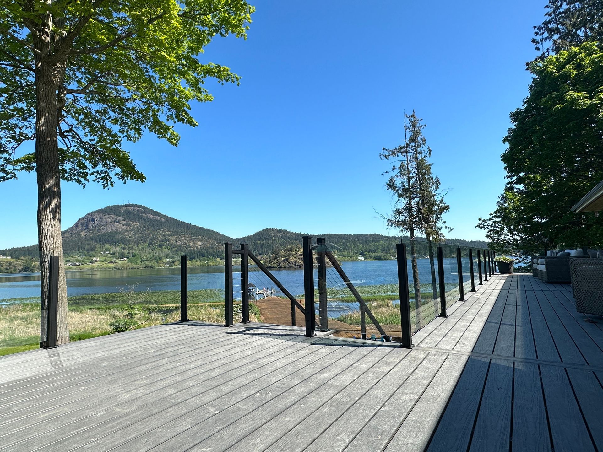 Newly installed deck floor, glass railing, and stairs