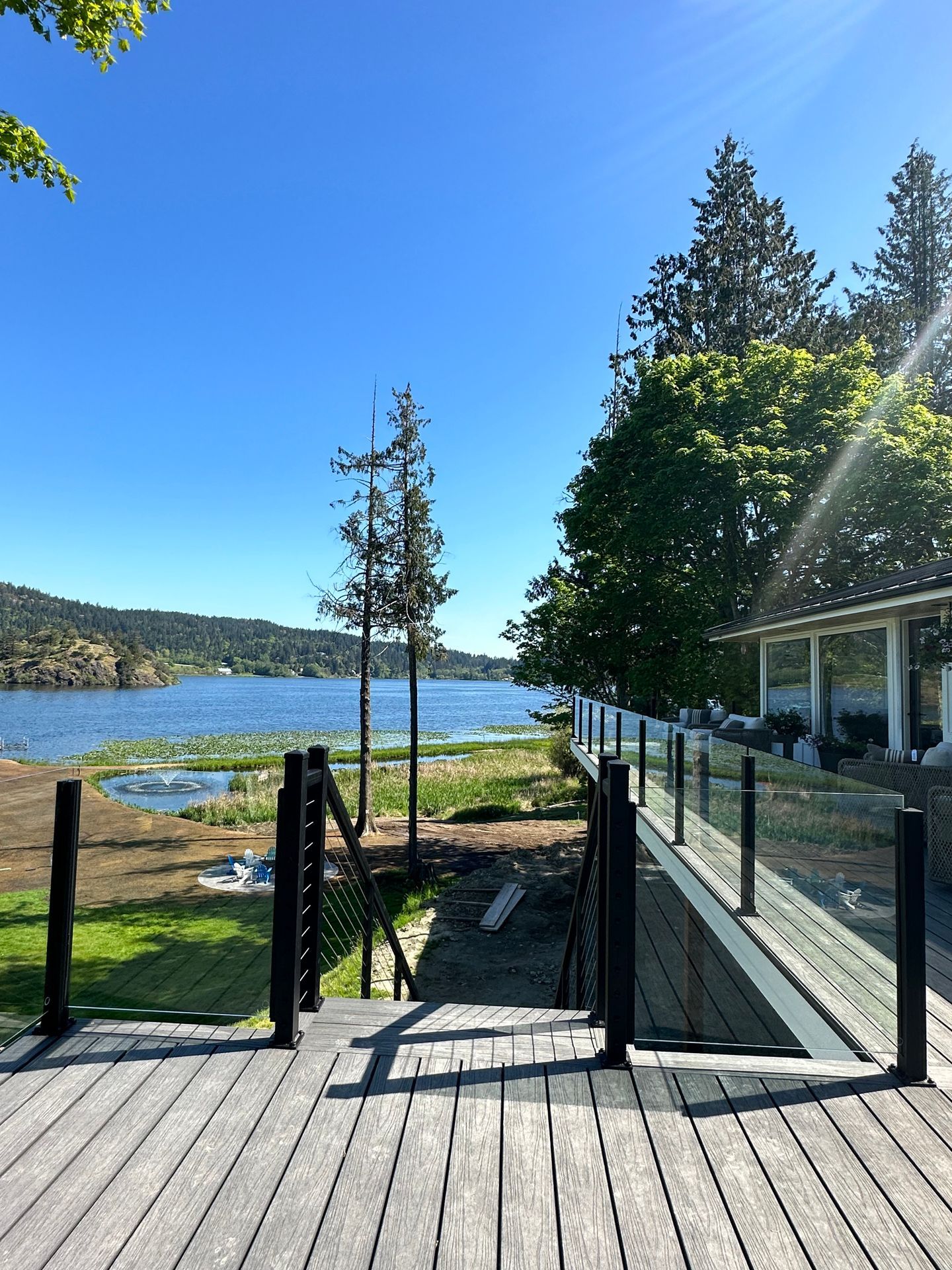 Newly installed deck floor, glass railing, and stair