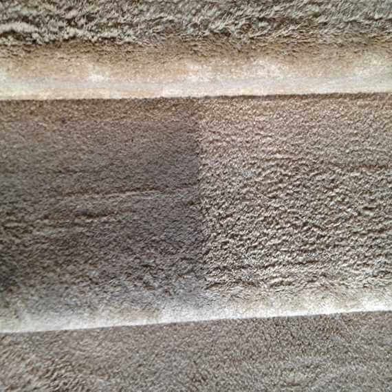 Close-up of a rough stone wall with horizontal layered textures in gray and beige.