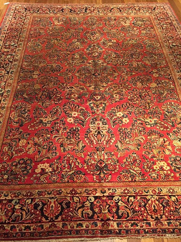 Red Oriental rug with floral patterns and border.
