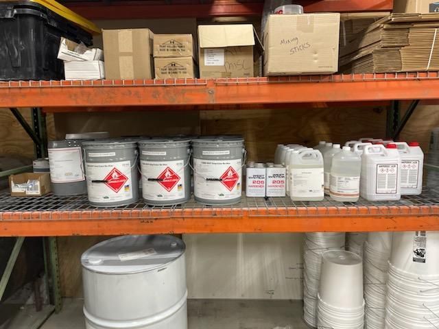 A warehouse filled with lots of barrels and containers of chemicals.