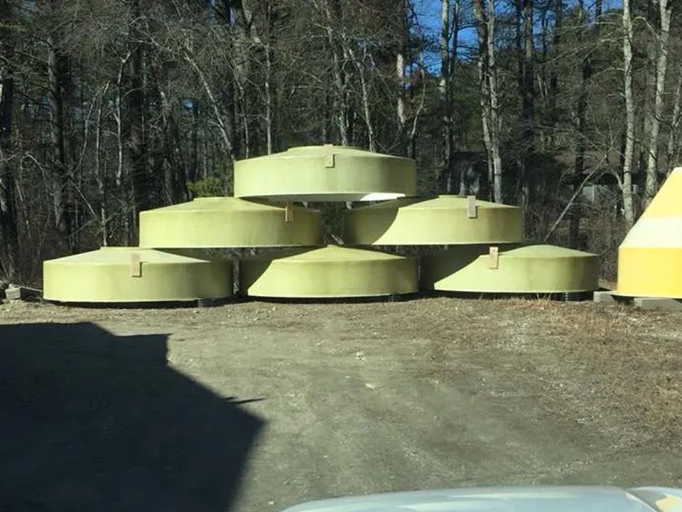 A stack of yellow and white buoys in a parking lot