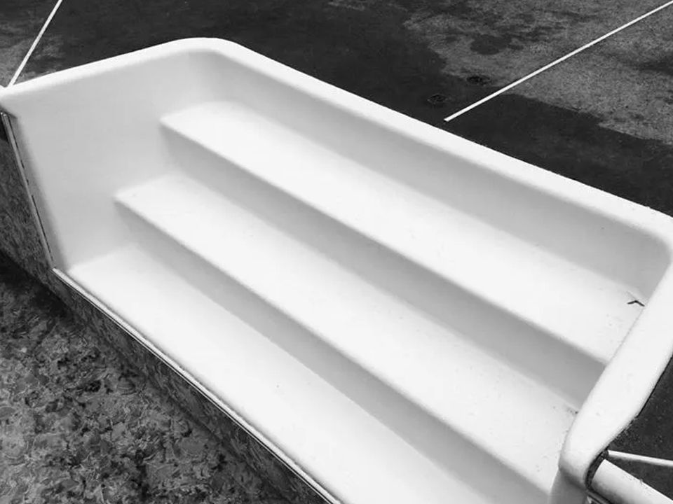 A black and white photo of a swimming pool with stairs