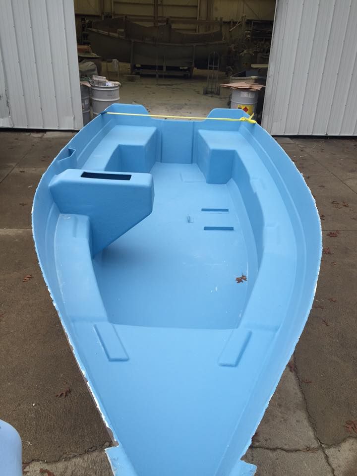 A blue boat is sitting in front of a white building