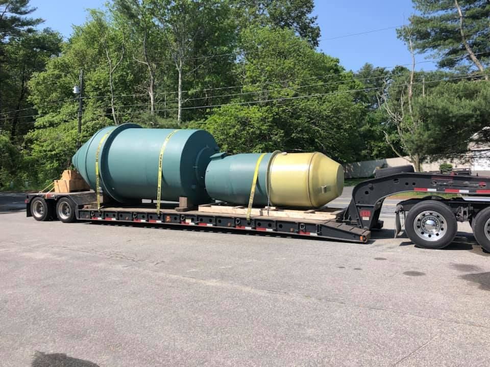 A large green and yellow object is being transported on a trailer.