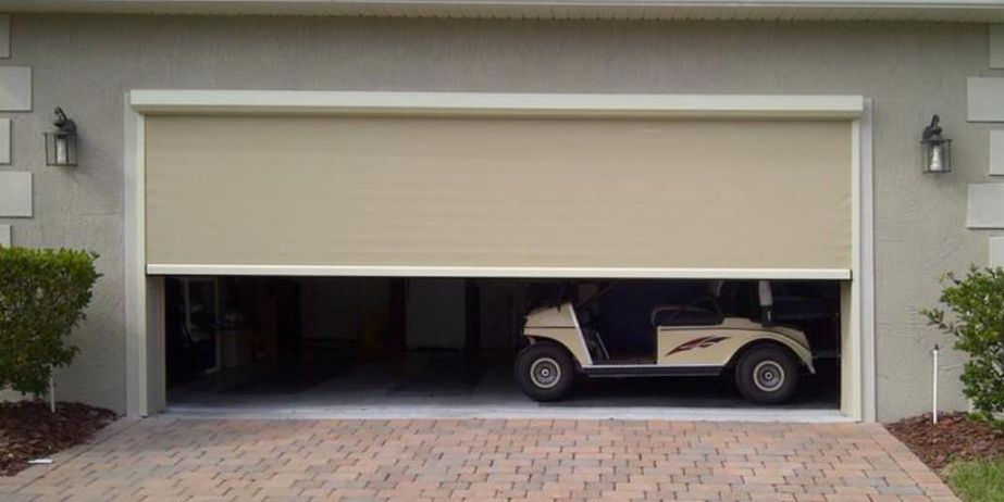 Beige garage door partially open, revealing a beige golf cart inside. Brick driveway in front of the garage.