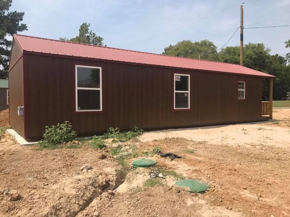 A brown building with a red roof and windows