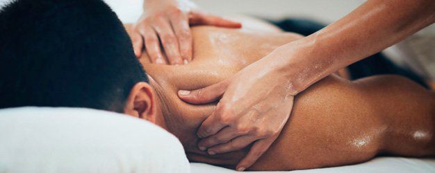 massage therapist massaging shoulders of a customer