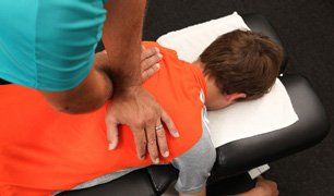 a chiropractor treating a young boy