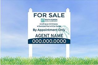 A for sale sign is sitting on top of a lush green field.