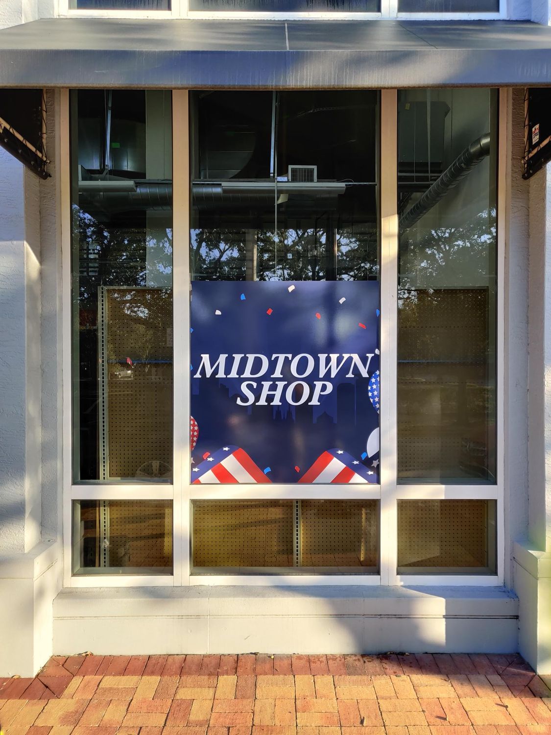A window with a sign that says midtown shop on it