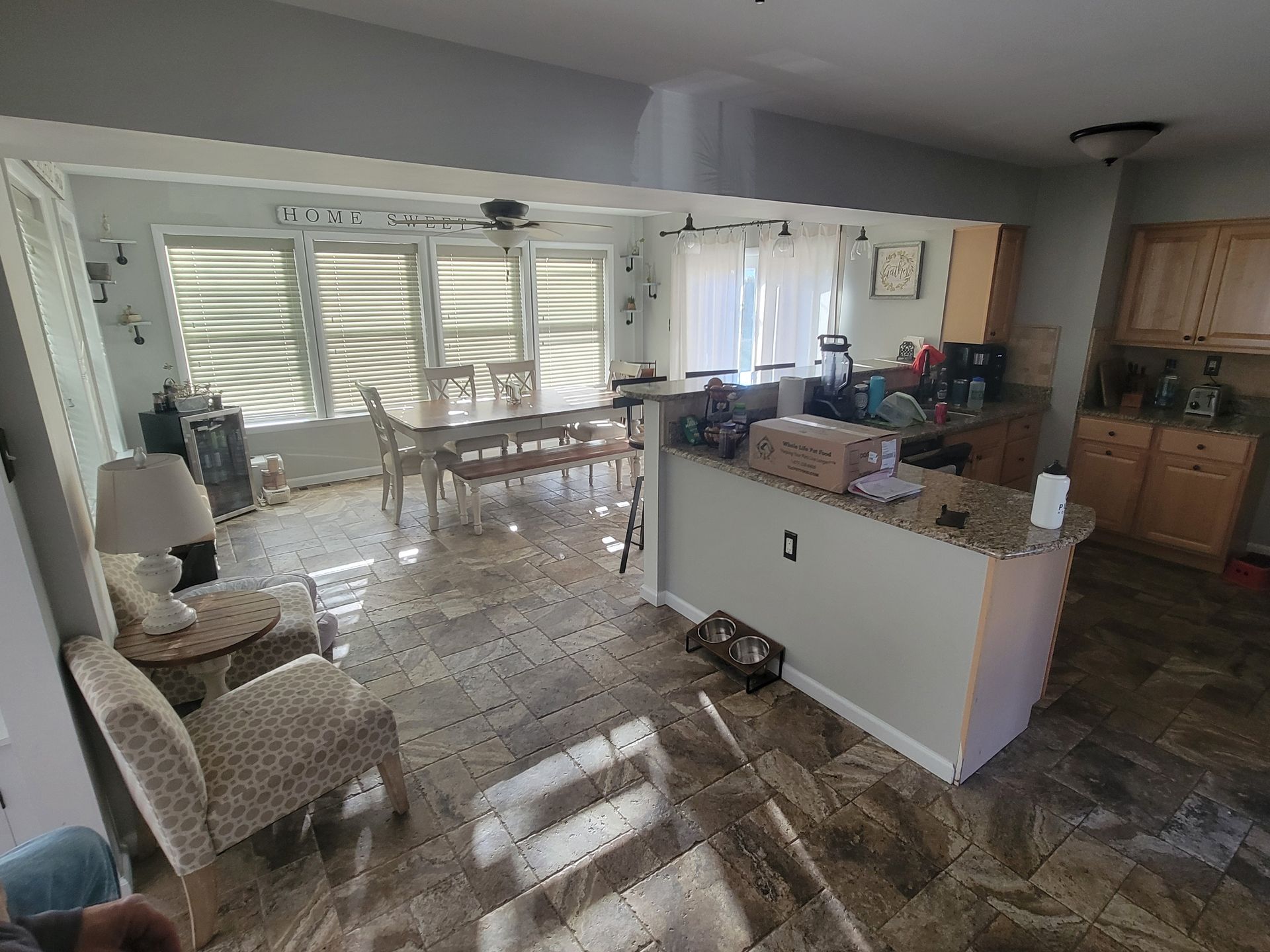 A living room with a dining table and chairs and a kitchen.