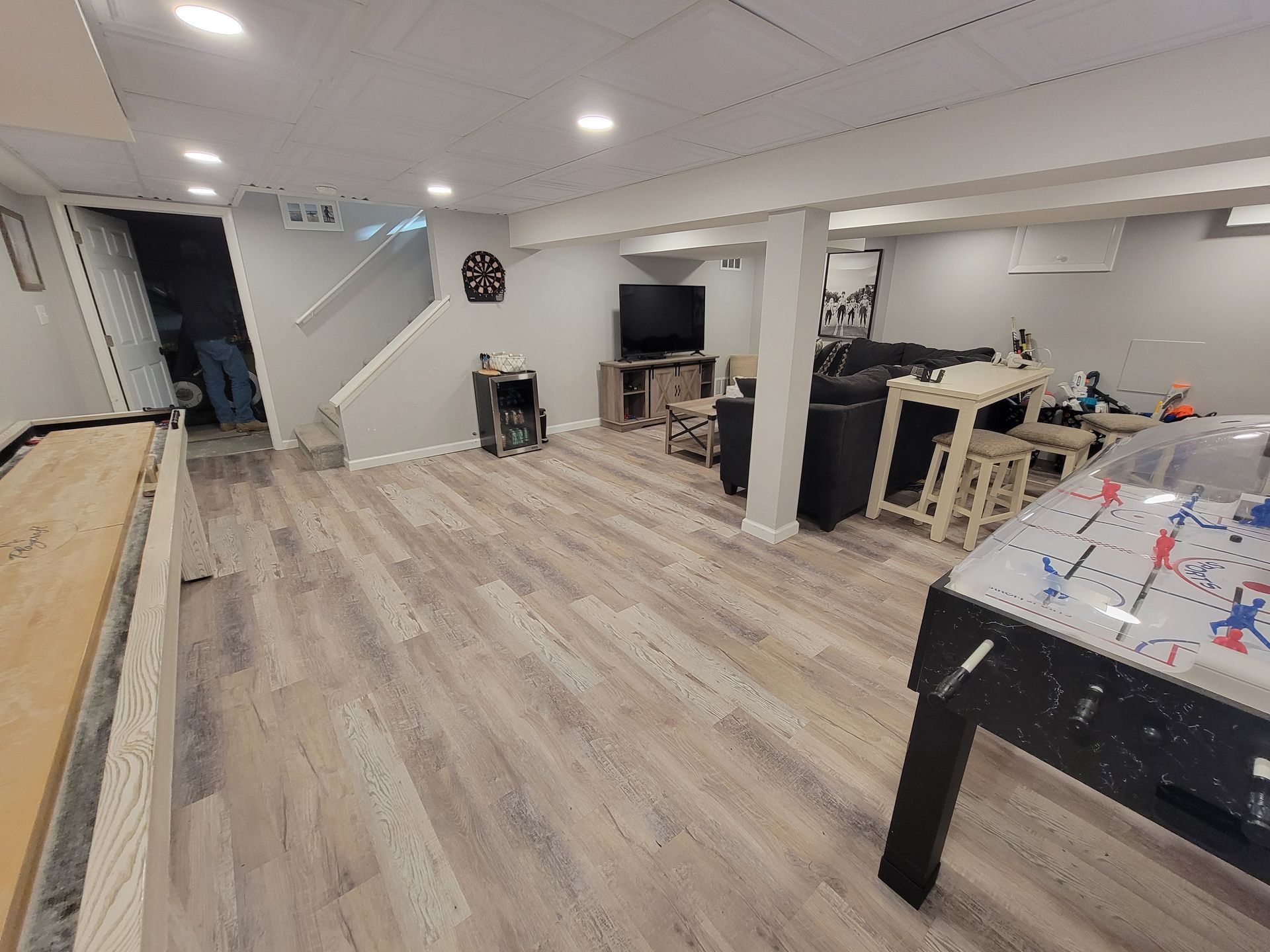 A basement with hardwood floors and a foosball table.