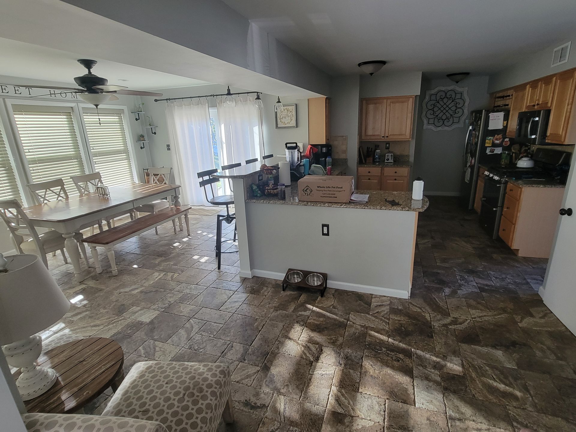 A living room picture with a dining room table and chairs and a kitchen.