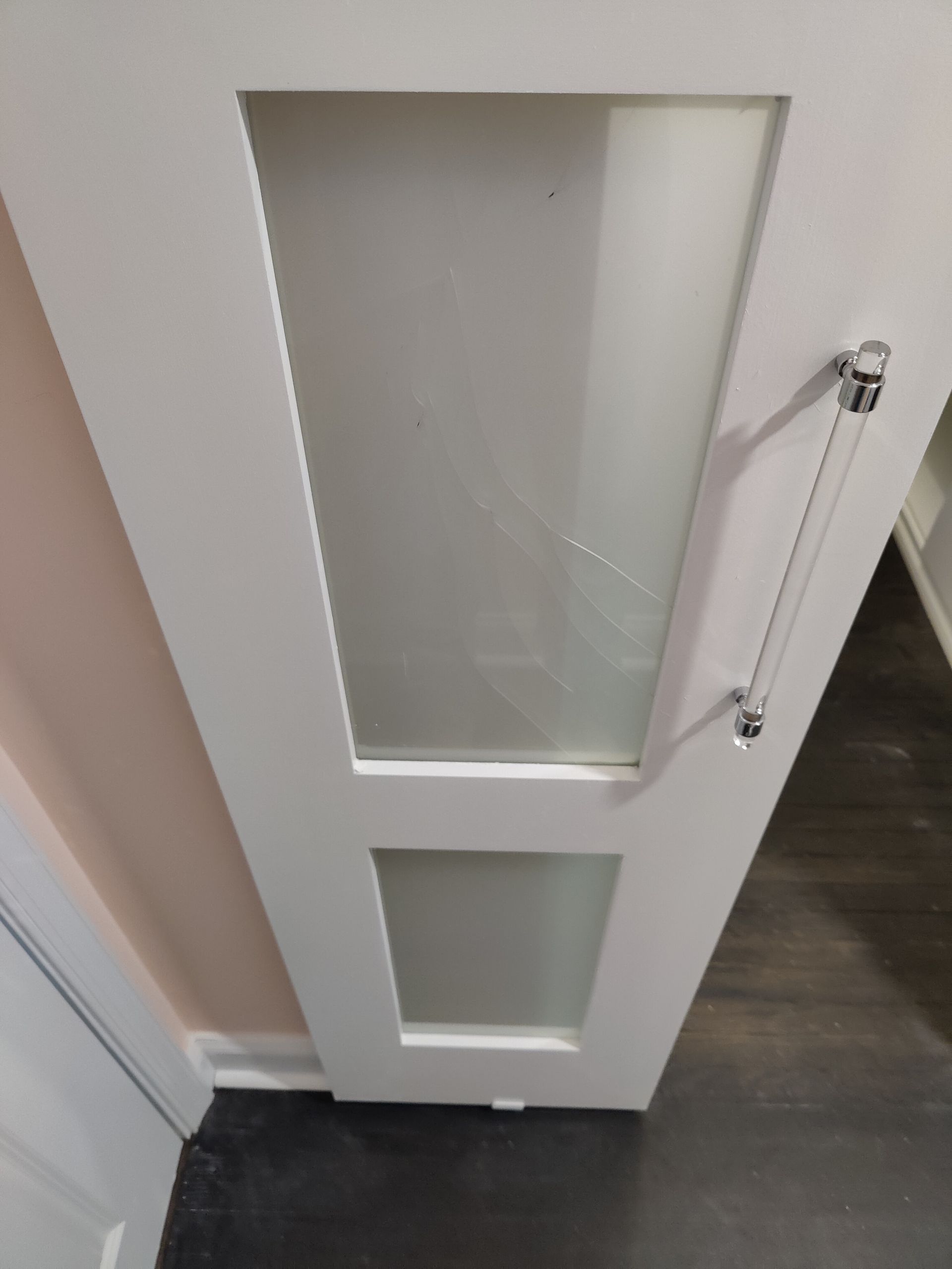 A white door with a clear glass panel and a handle.