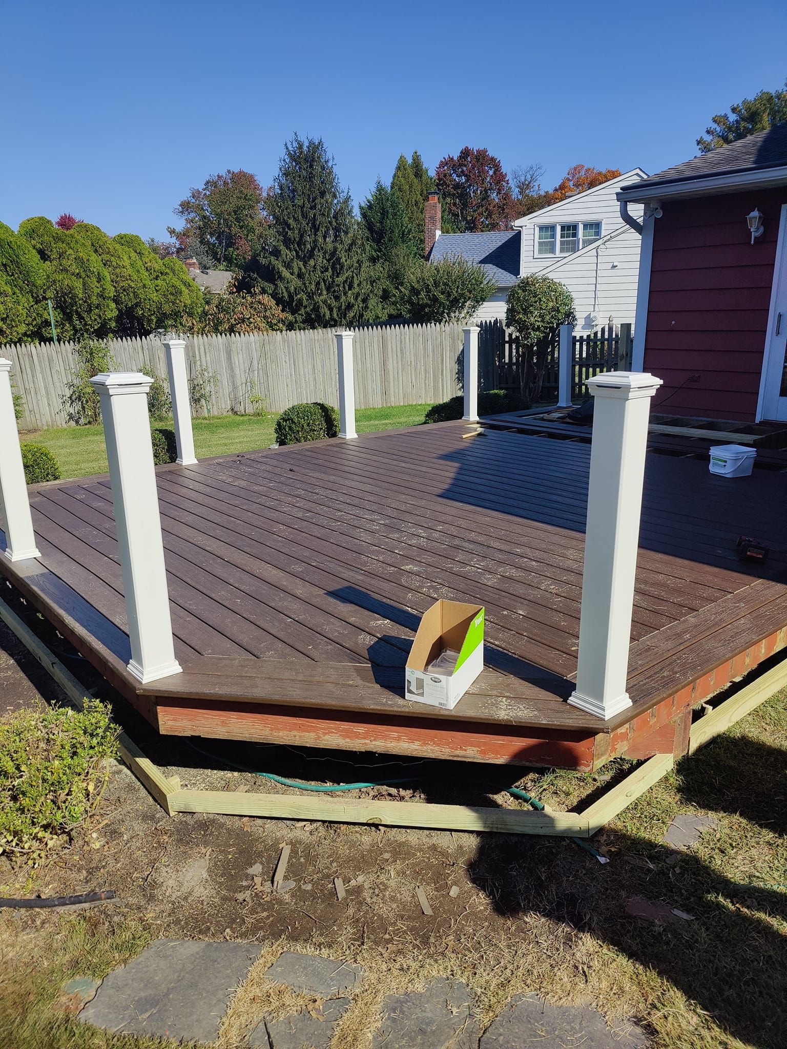 A wooden deck is being built in the backyard of a house.