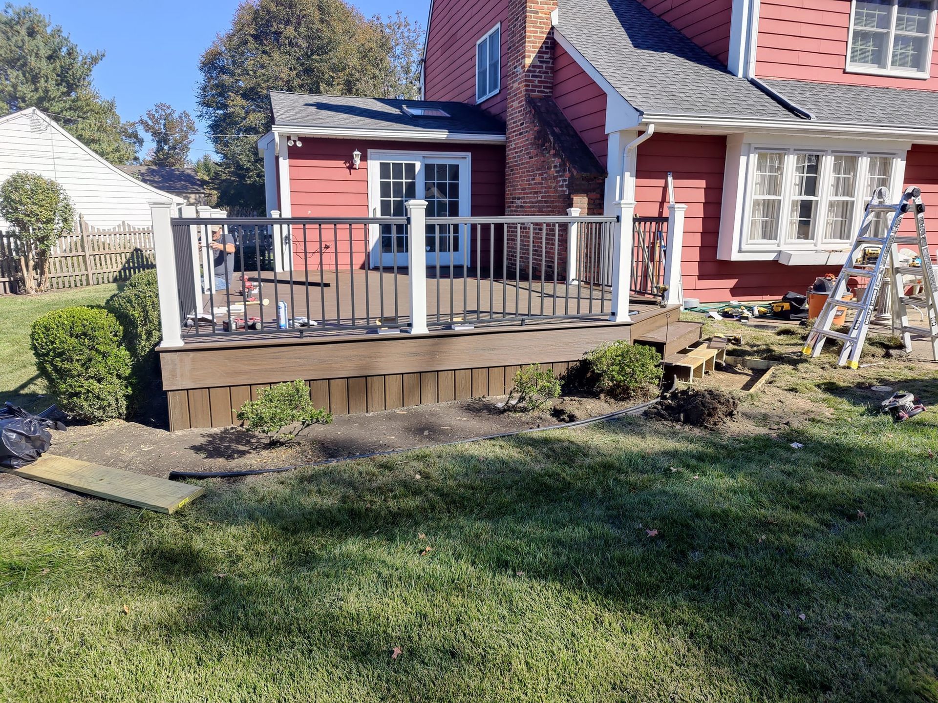 A red house with a wooden deck in front of it.