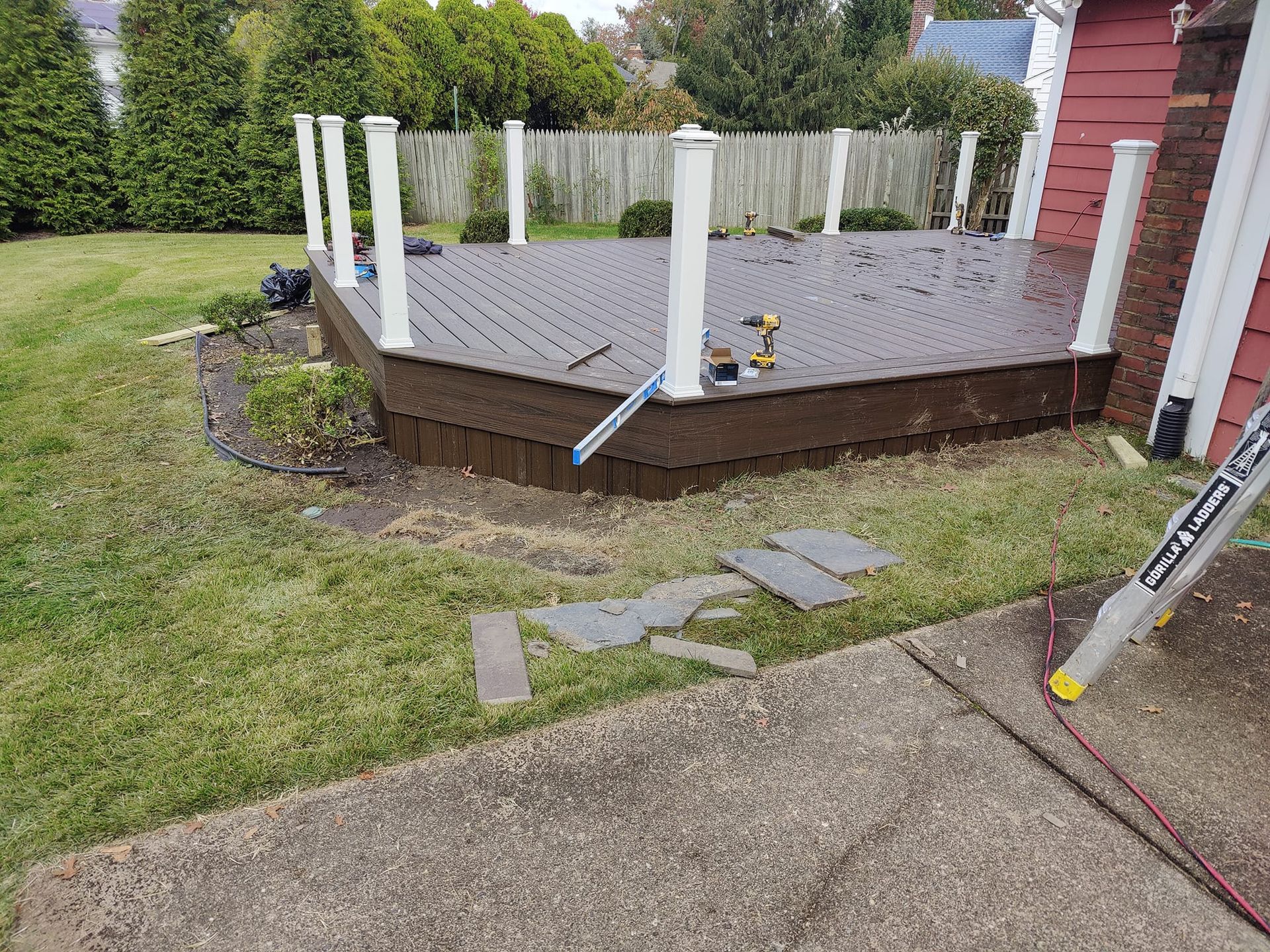 A wooden deck is being built in the backyard of a house.