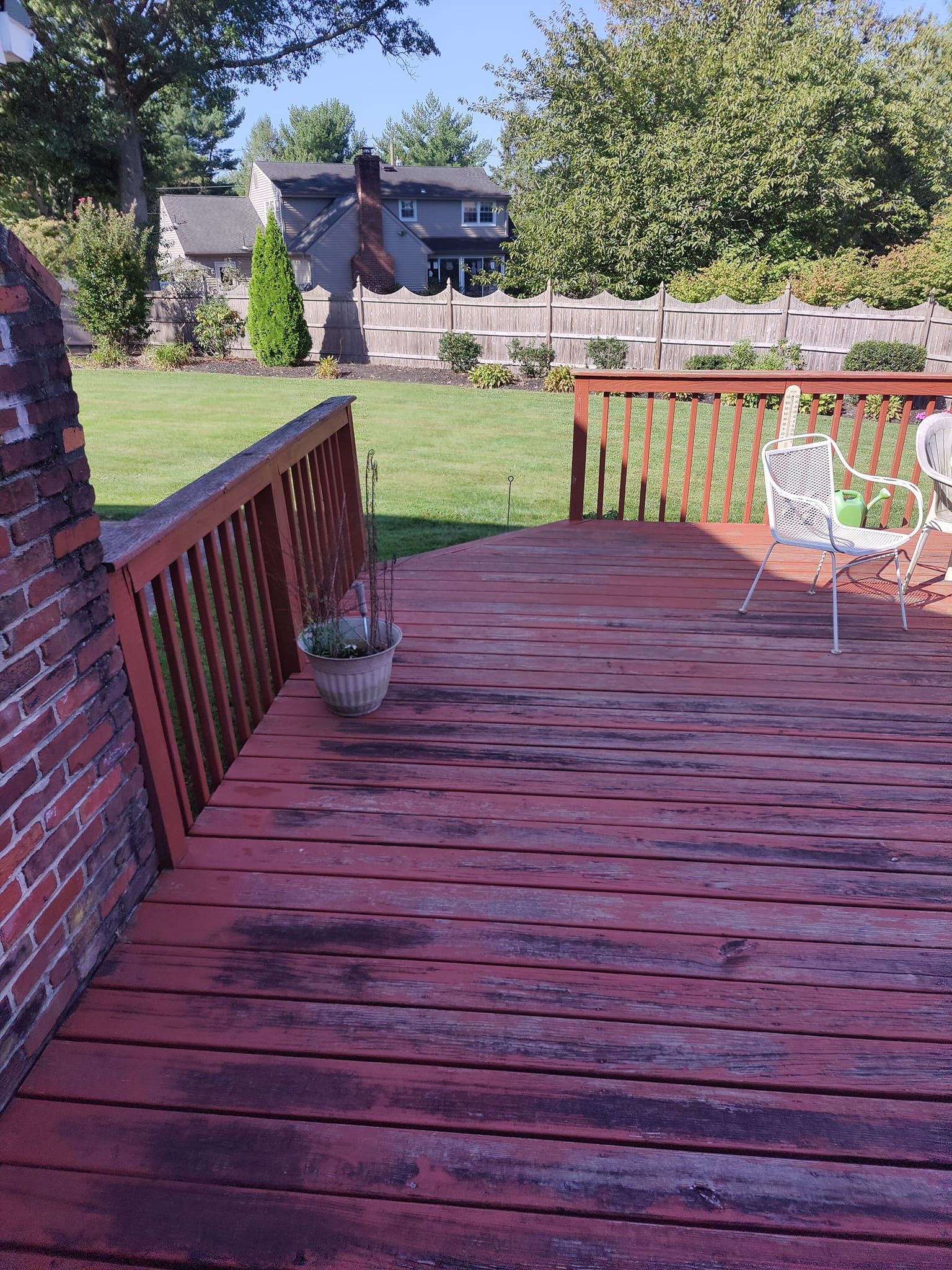 A wooden deck with a chair and a potted plant on it.