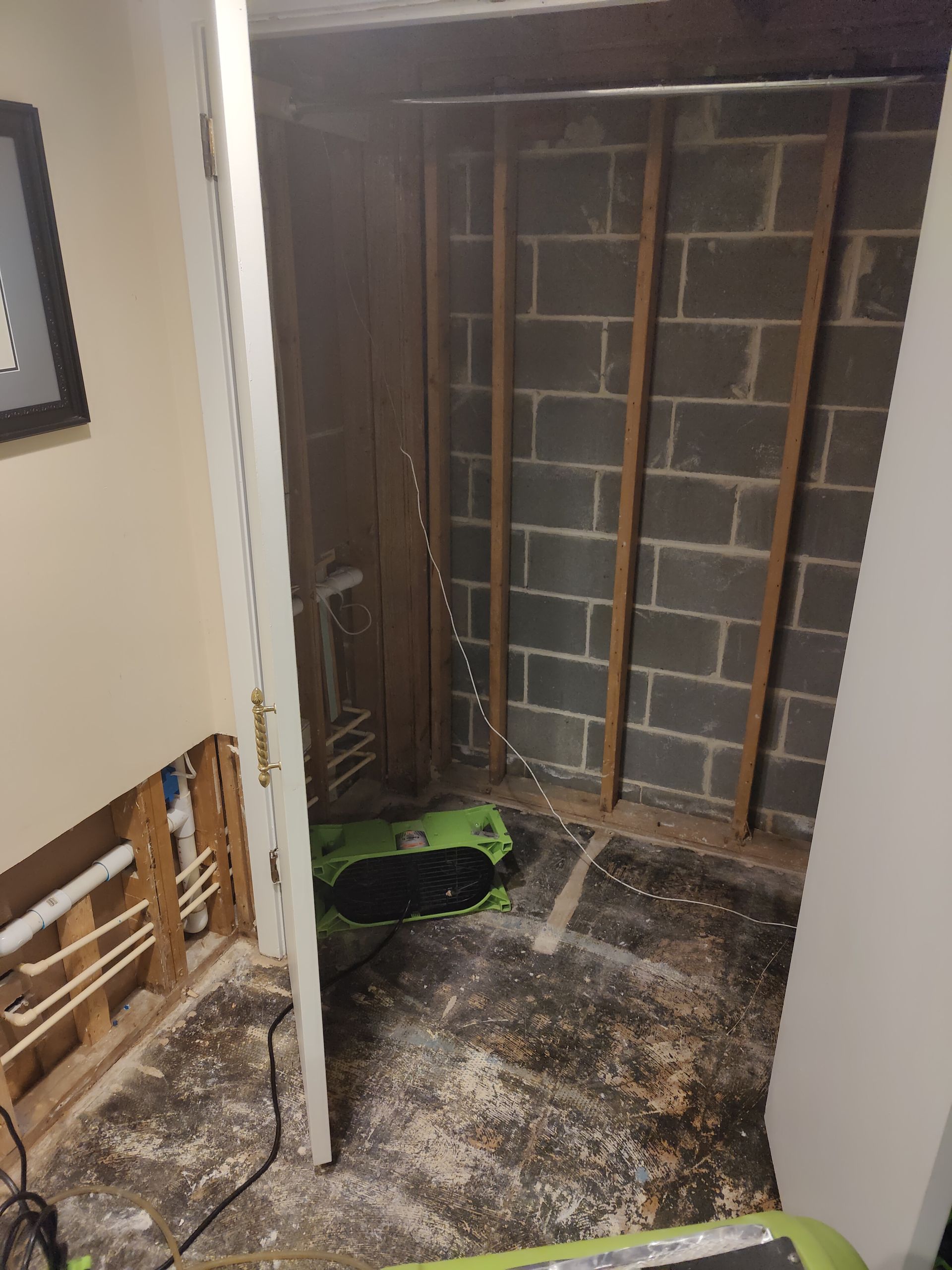 A room with a brick wall and a door that is open.