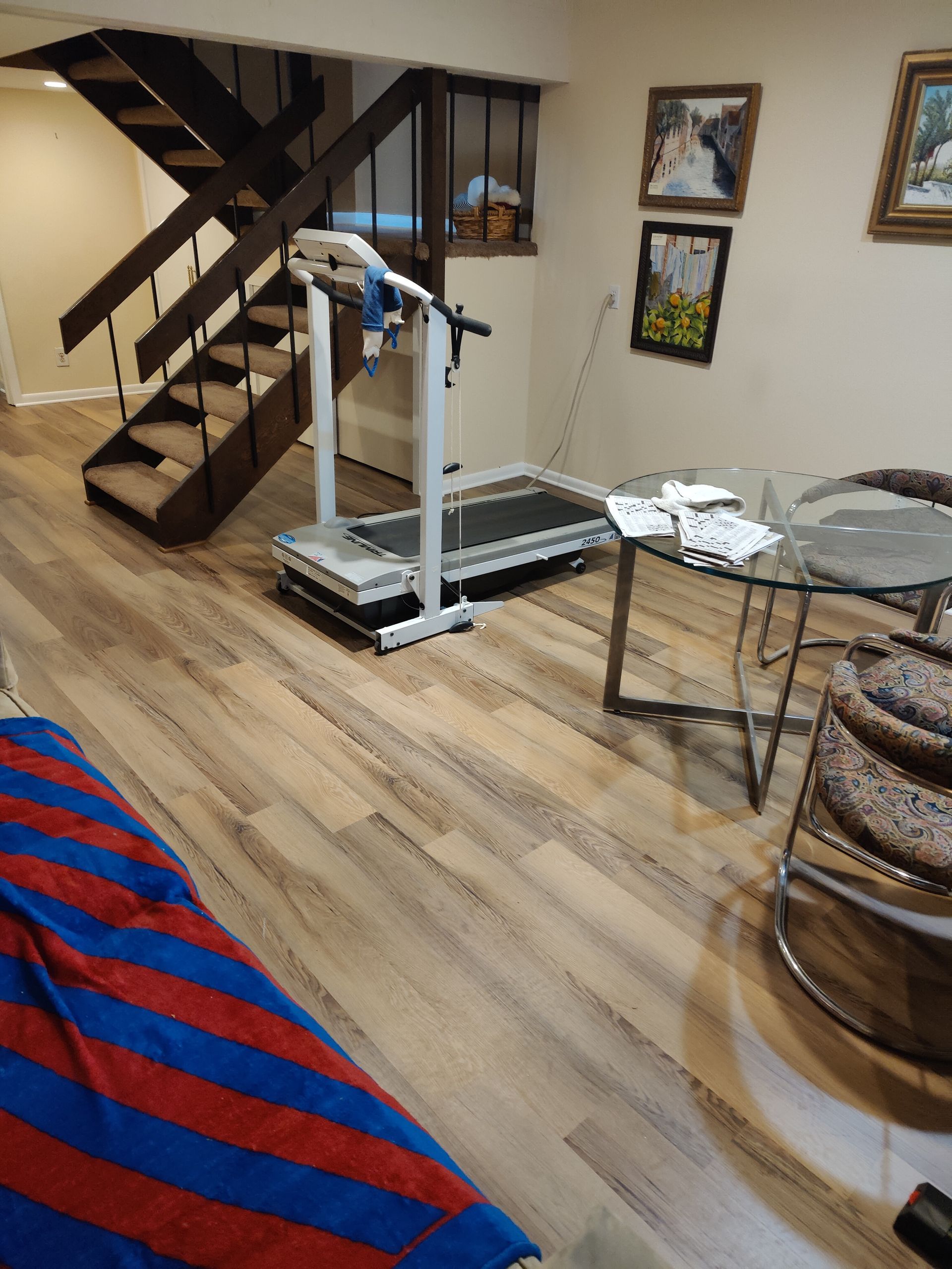 A room with a treadmill and stairs in it.