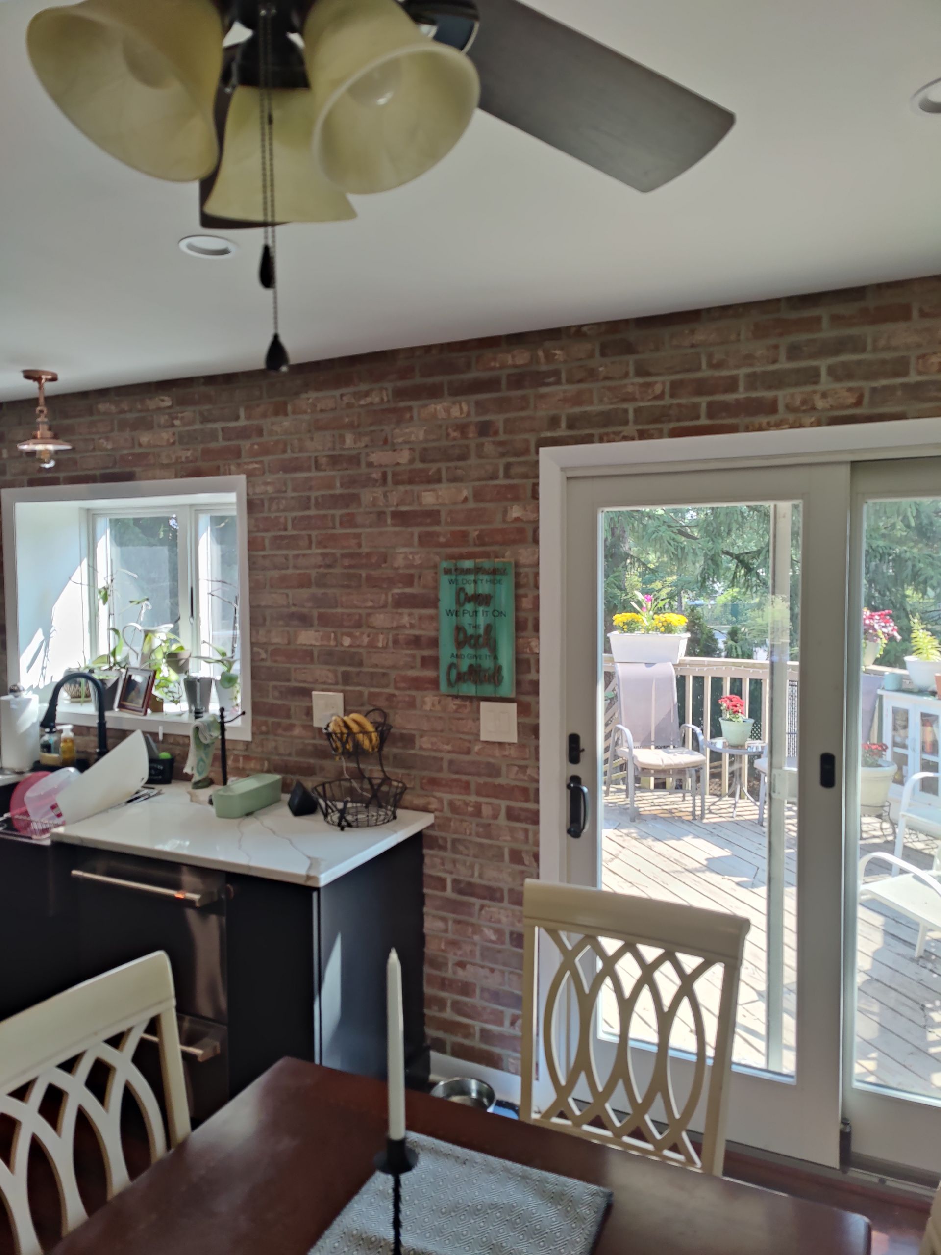 A kitchen with a table and chairs and a ceiling fan.