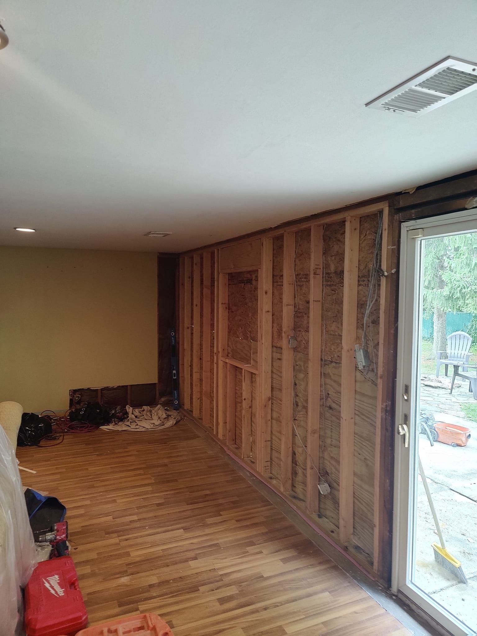 A room with wooden walls and a sliding glass door.