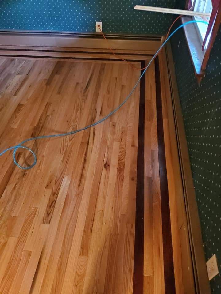 A wooden floor with a blue cord hanging from it in a room.