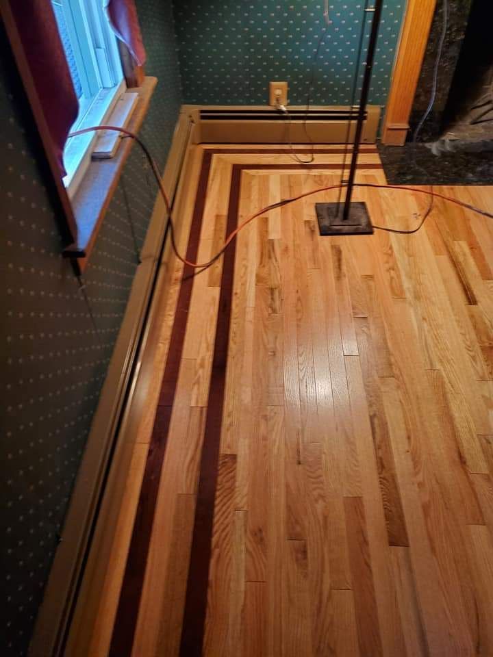 A wooden floor in a room with a lamp on it.
