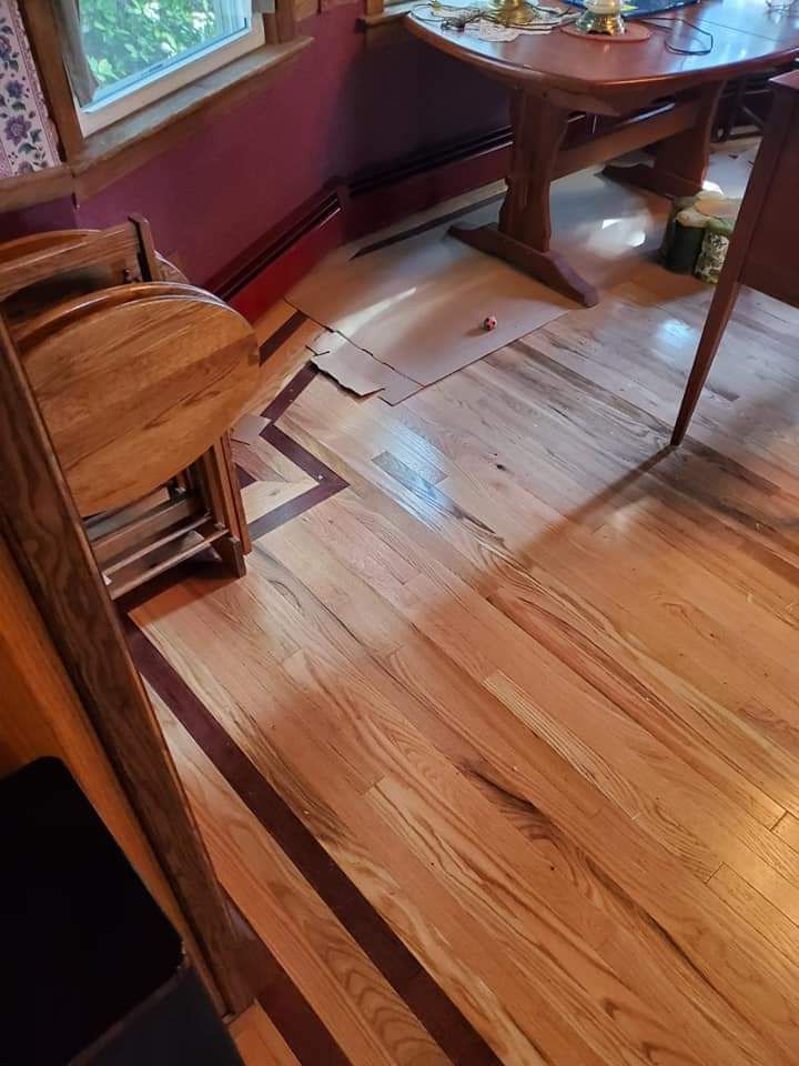 A wooden floor in a room with a table and chairs.