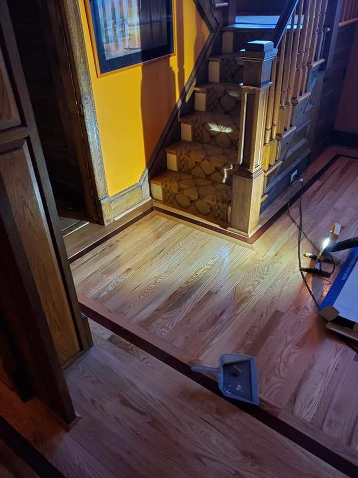A wooden staircase in a house with a vacuum cleaner on the floor.
