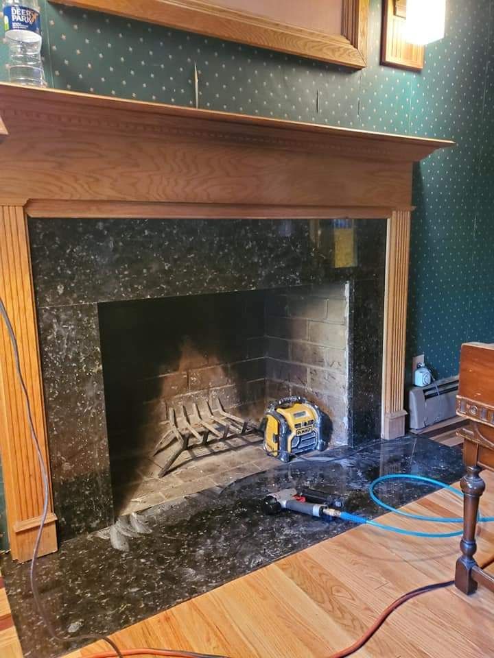 A fireplace in a living room with a wooden mantle.