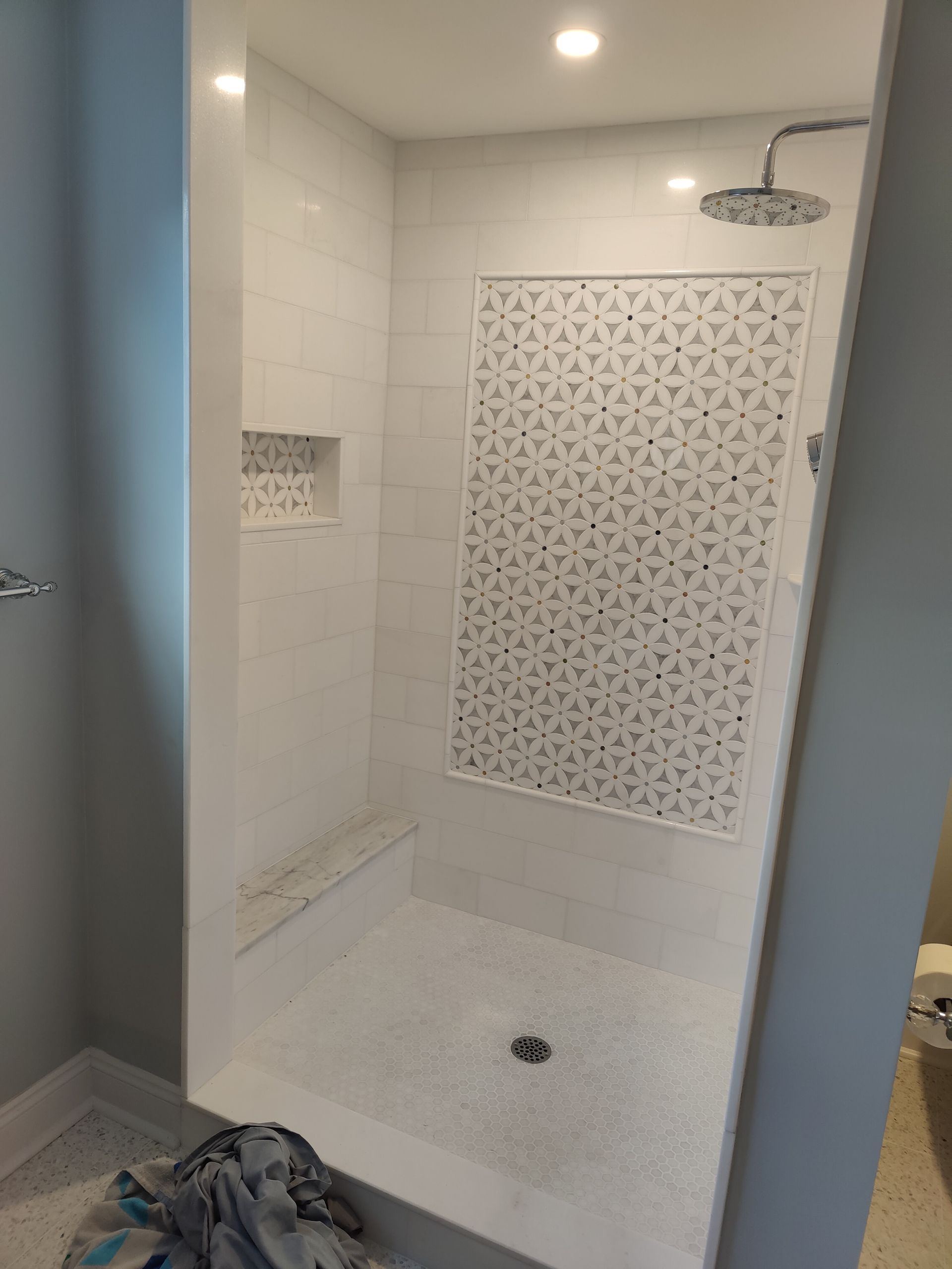 A bathroom with a walk in shower and a shower head.