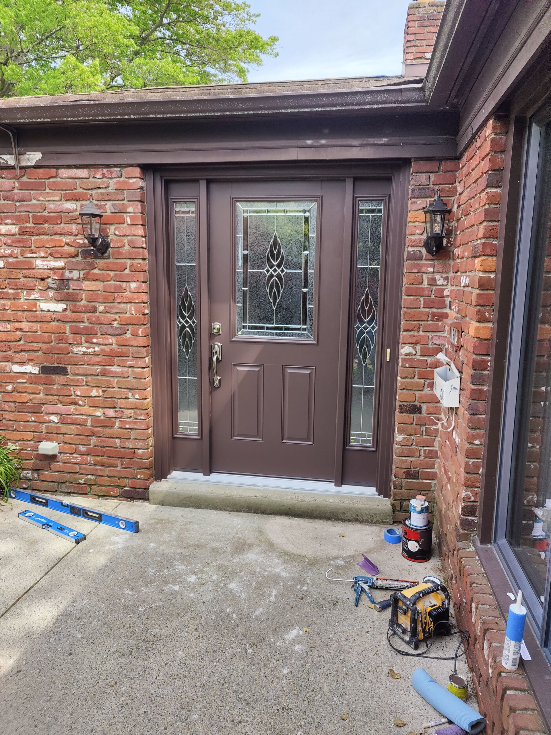 The front door of a brick house is being remodeled.