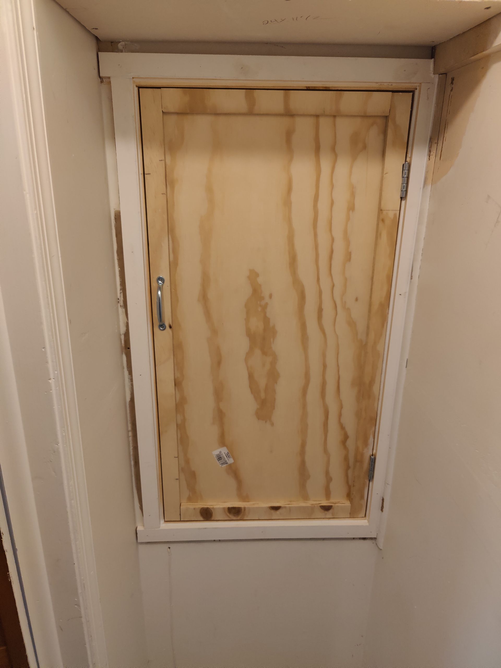 A wooden door is sitting in a corner of a room.