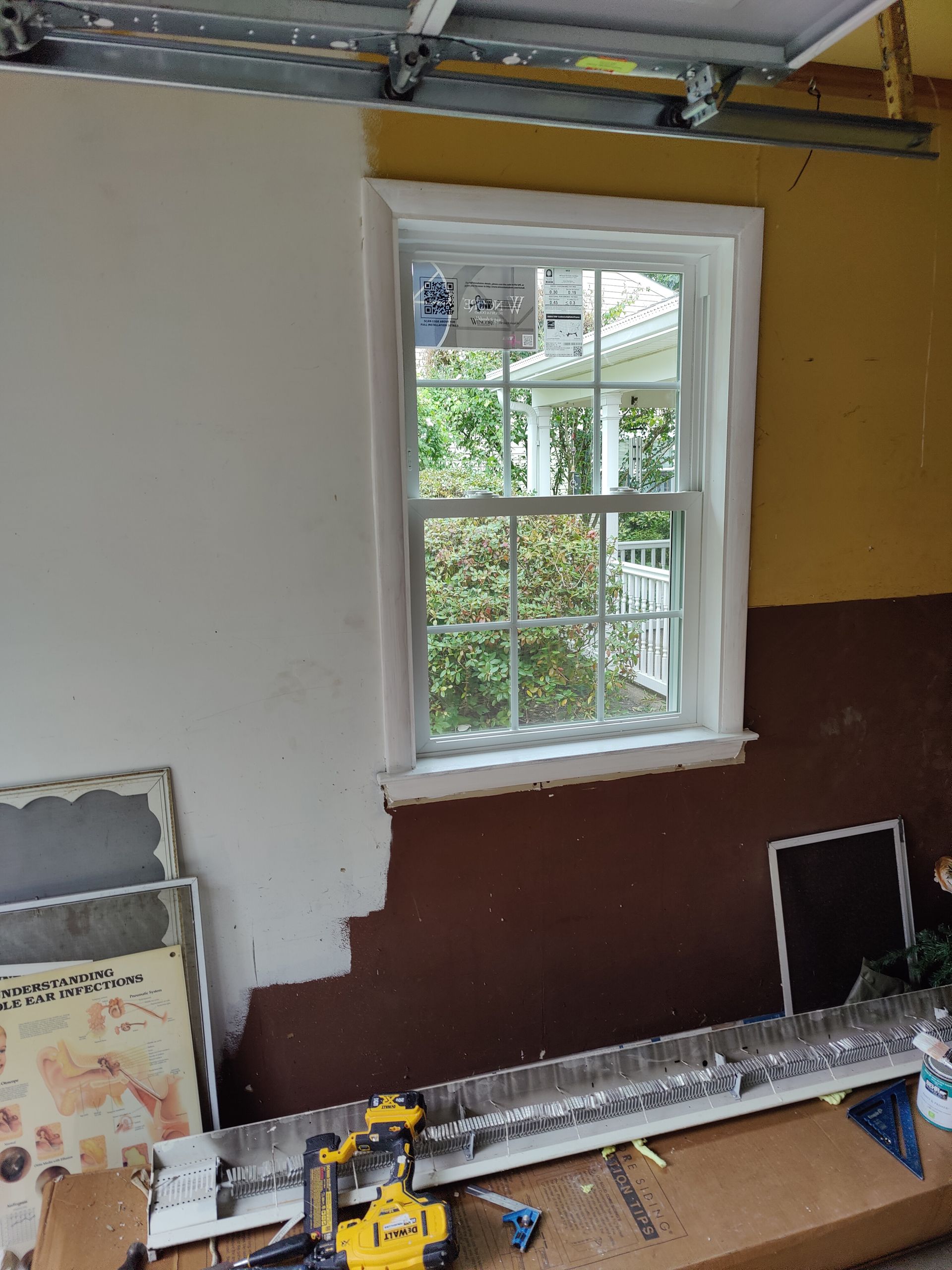A window is being installed in a garage.